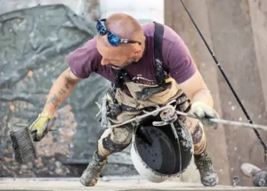 A man doing plastering on a wall seasonal job, while thinking how to allocate his irregular income
